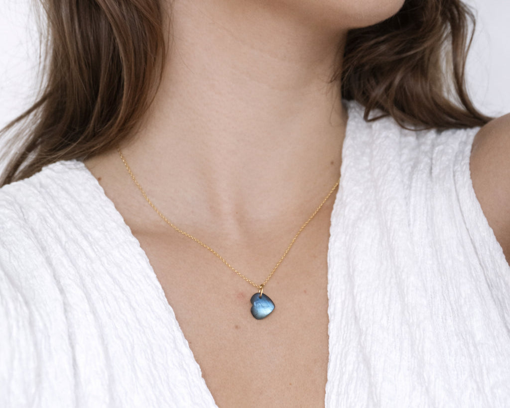 Modelo con colgante de labradorita con forma de corazon y cadena de plata con baño de oro